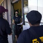 An outreach team goes door to door to educate the community on vaccines.