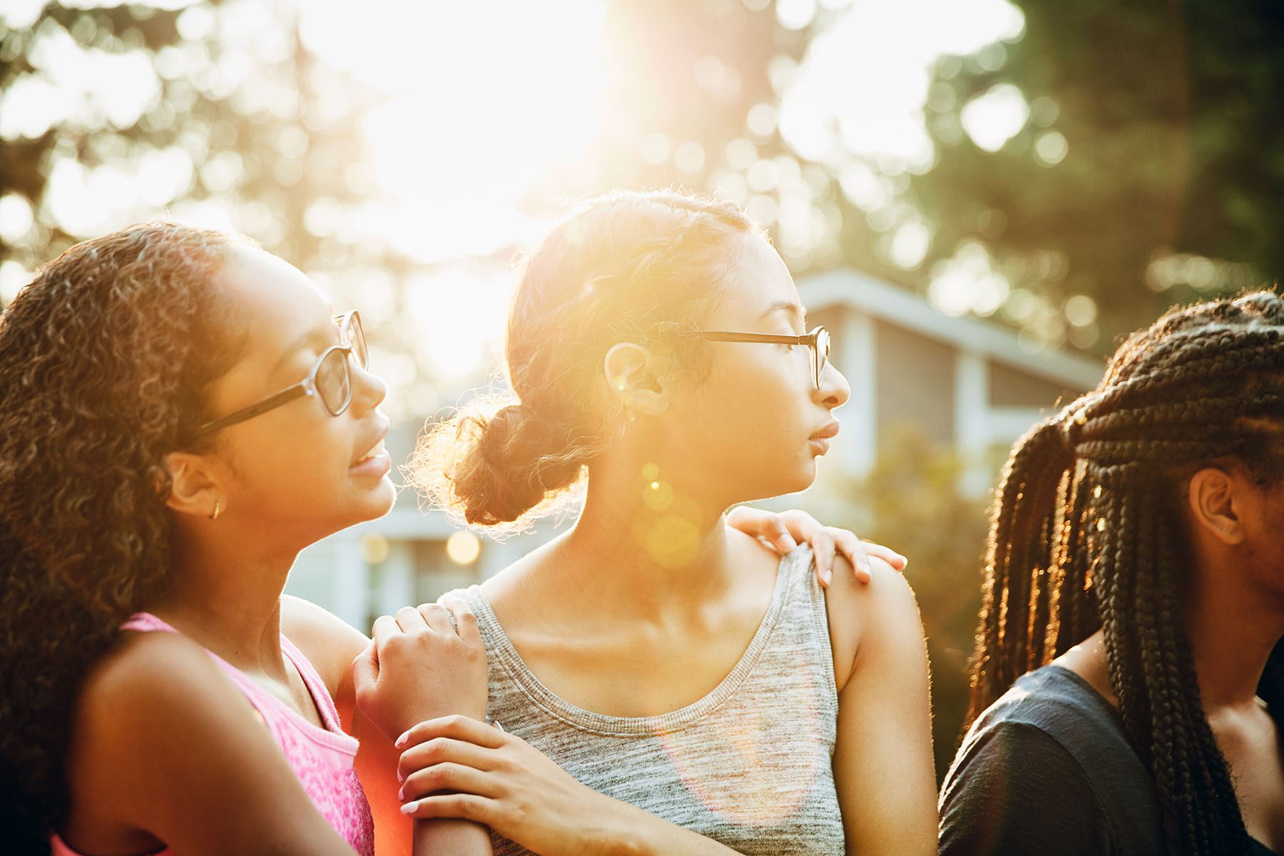 Young black girls hanging out together in a neighborhood on a summer evening.