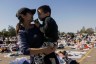 A mom holds her son as they look for clothes at a donation center in Santa Anita Park, Arcadia, California after being displaced by the Eaton Fire.