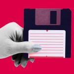 A hand holding a floppy disk.