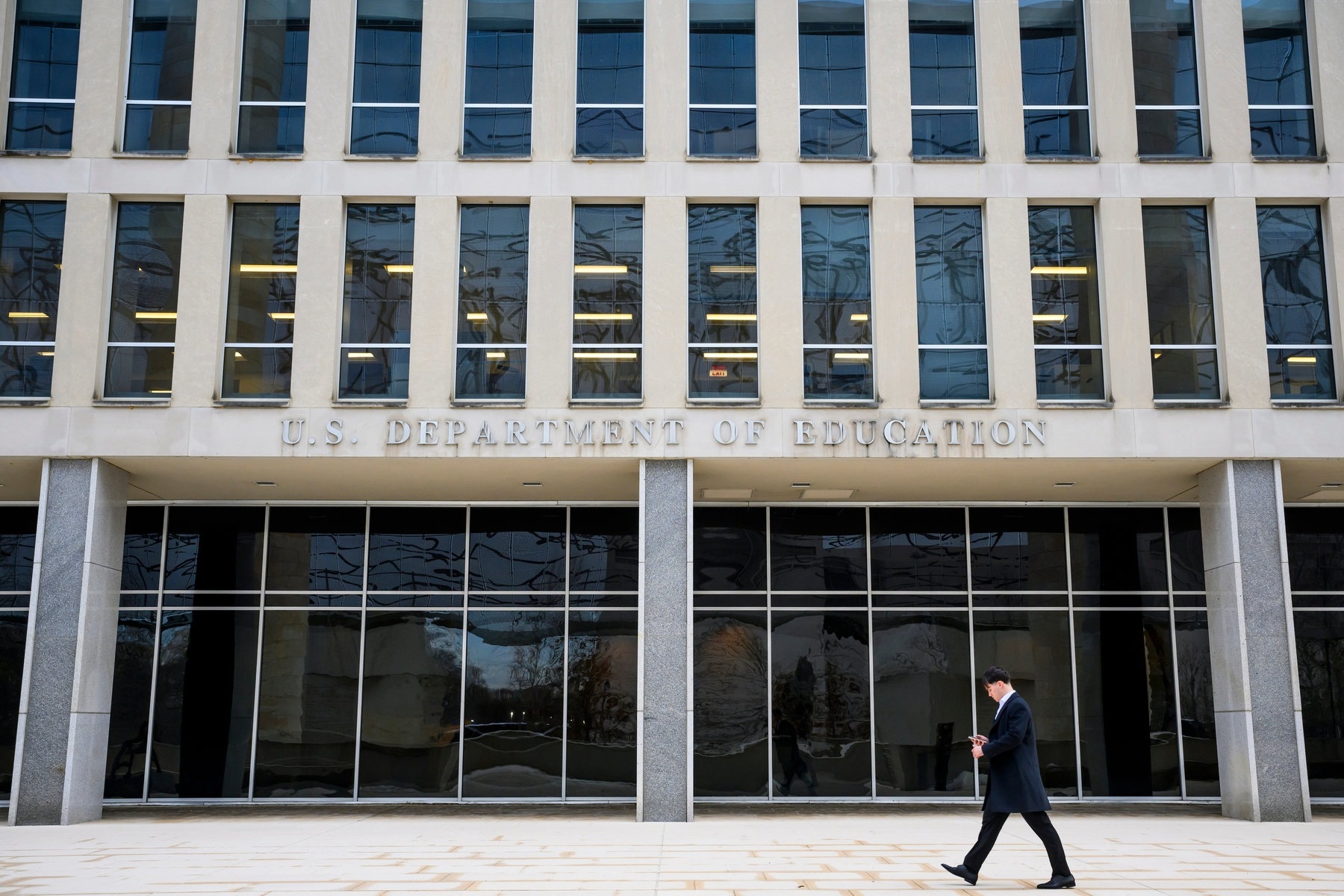A pedestrian walks by The Lyndon Baines Johnson Department of Education Building.