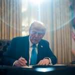 President Donald Trump signs executive orders in the Oval Office at the White House.