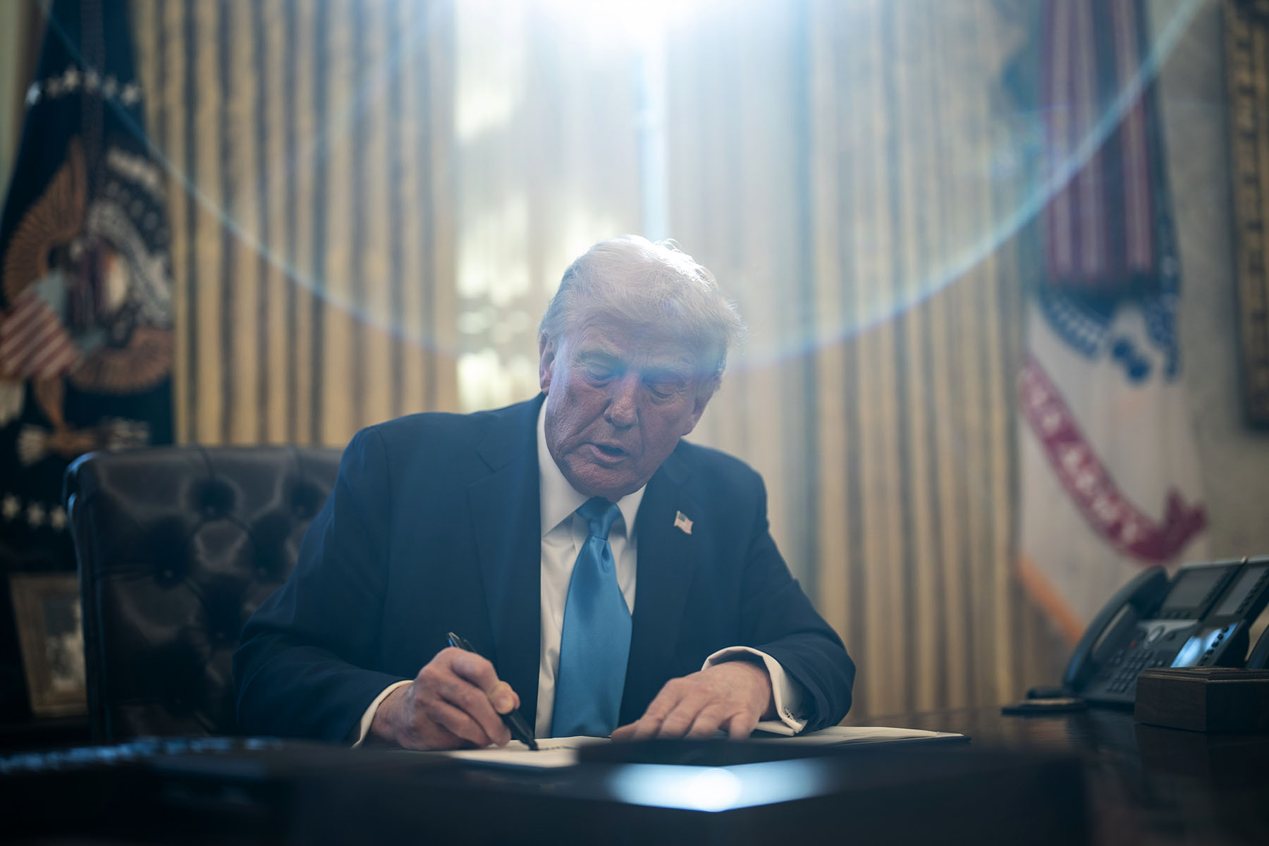 President Donald Trump signs executive orders in the Oval Office at the White House.
