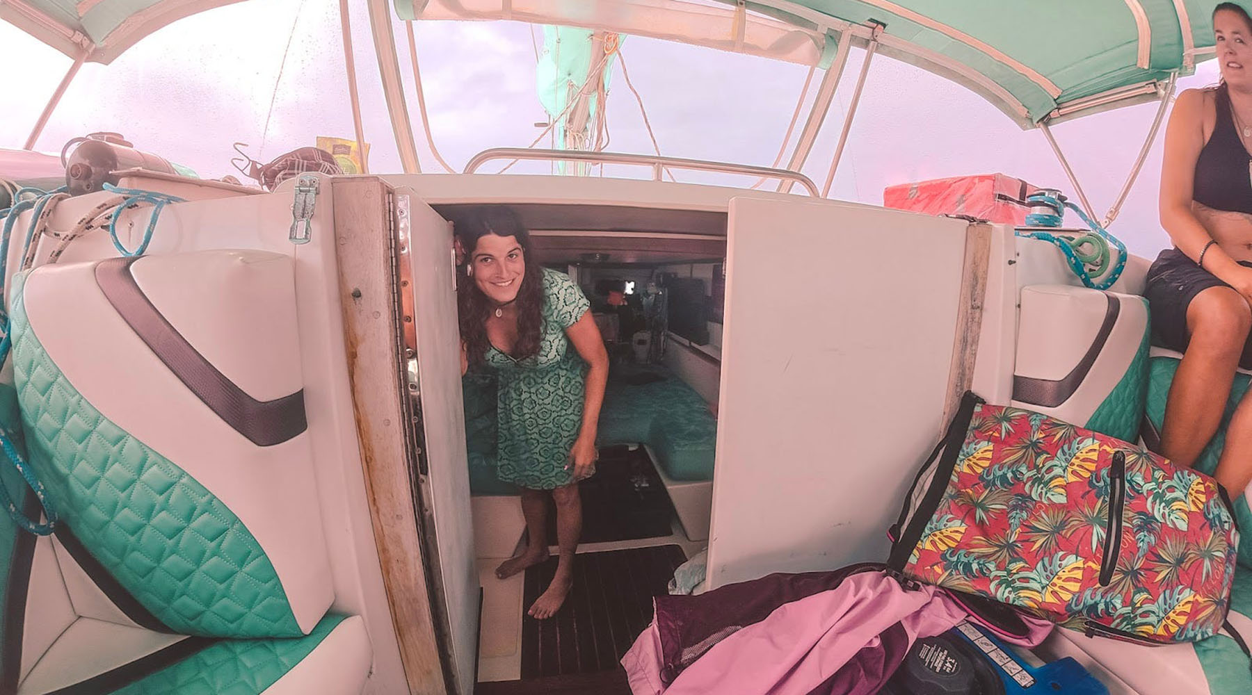 Kelsey Granger smiles as she stands in the doorway leading below deck on a sailboat.