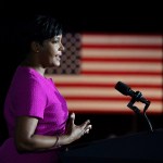 Keisha Lance Bottoms stands at a podium in front of an American flag.